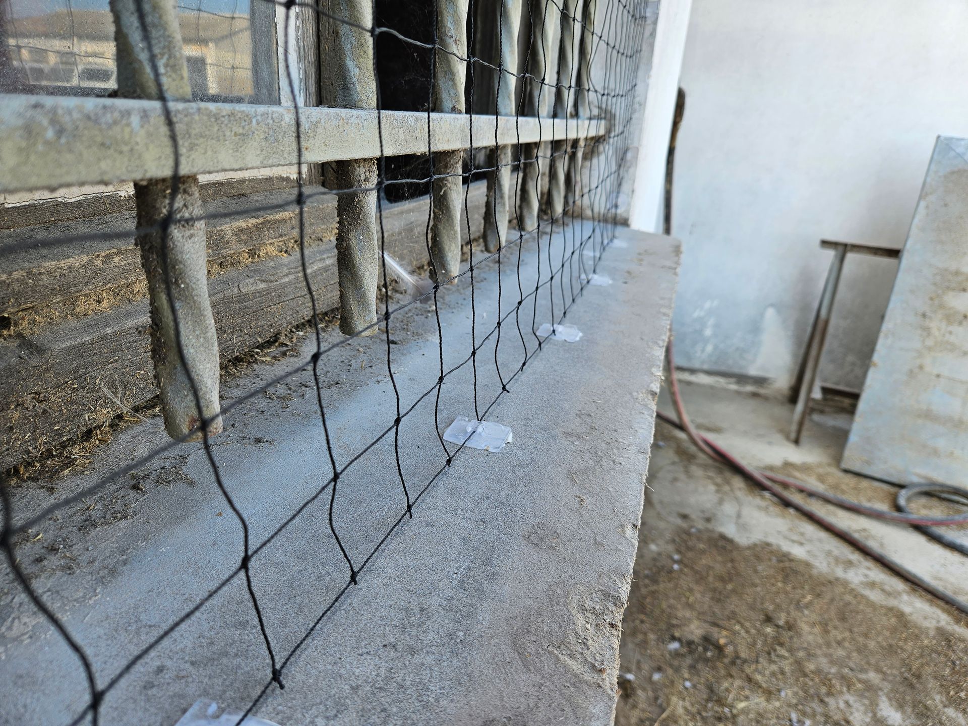 Une clôture est en train d'être installée sur un mur de béton.