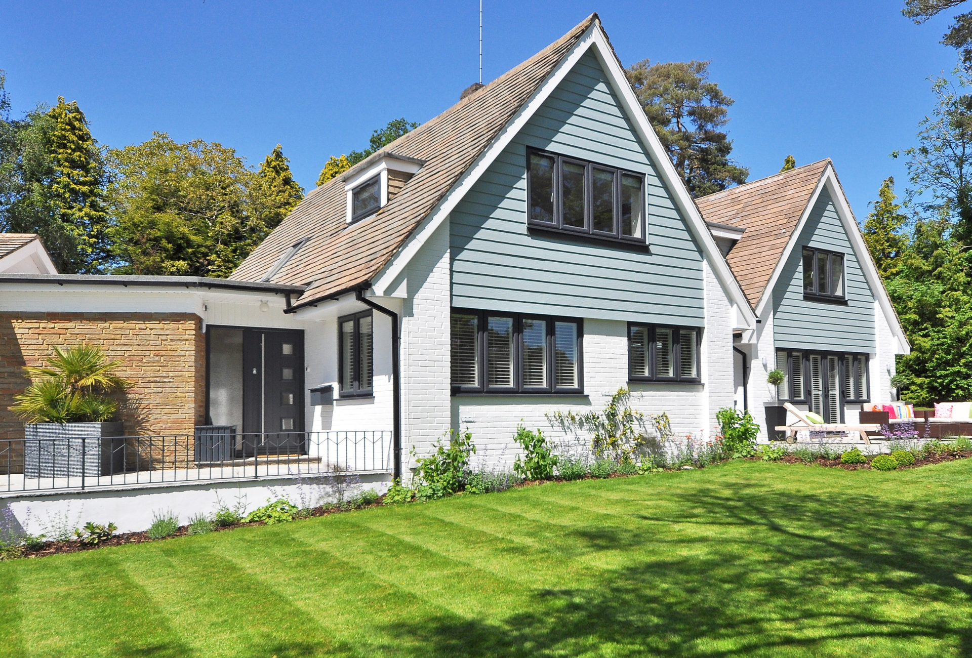 A large house with a lush green lawn in front of it.