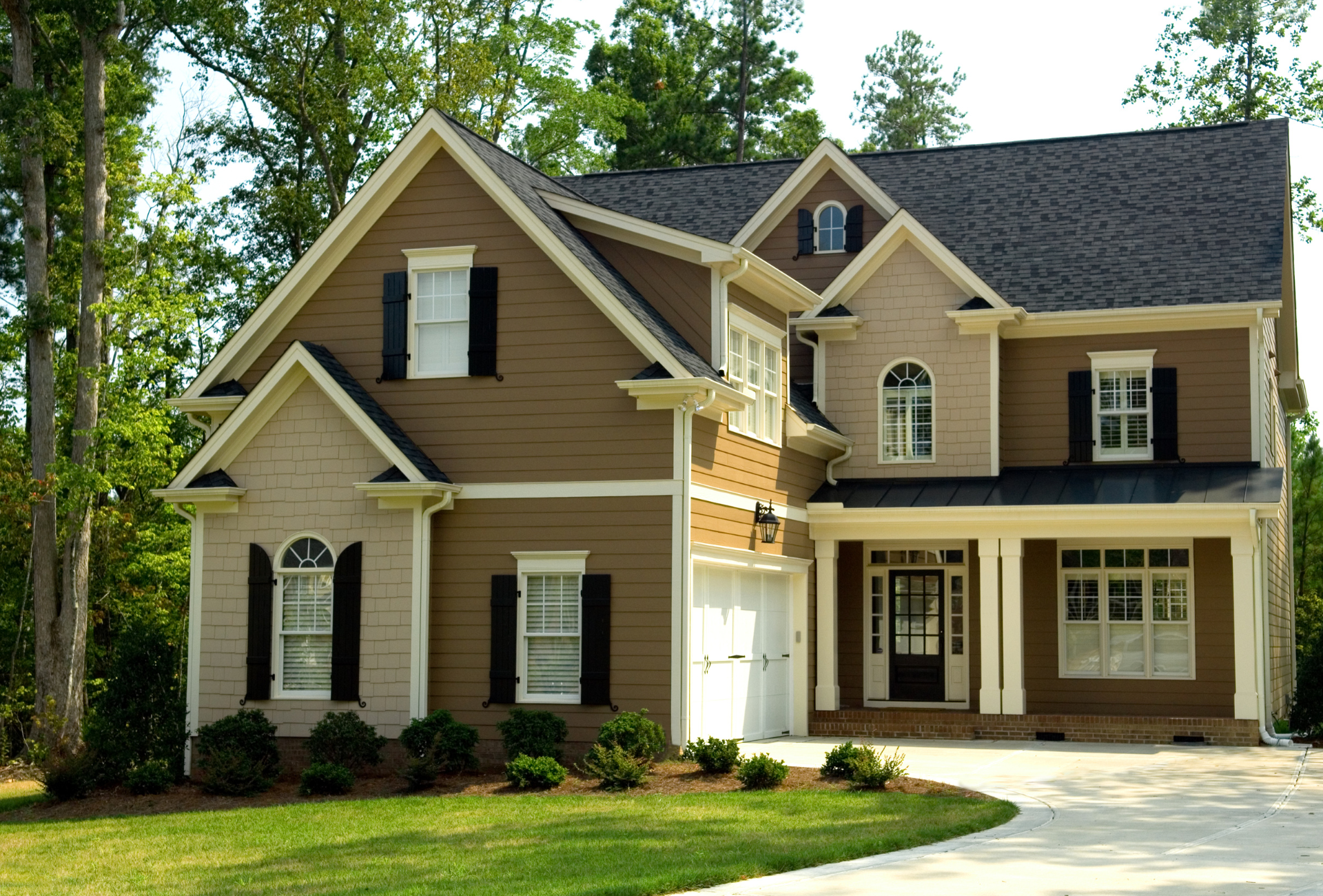 A large brown and white house with black shutters