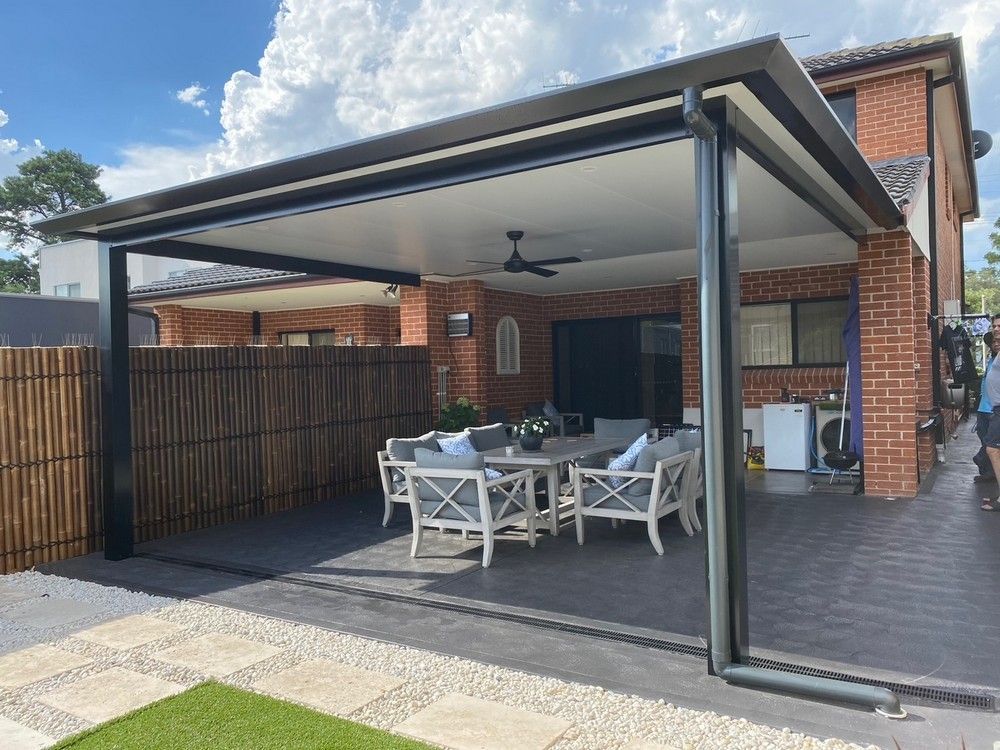 A man is hammering a nail into a wooden fence.