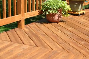 A wooden deck with a potted plant on it.