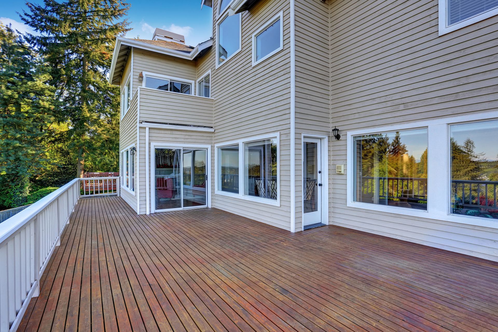 A large house with a large wooden deck in front of it.