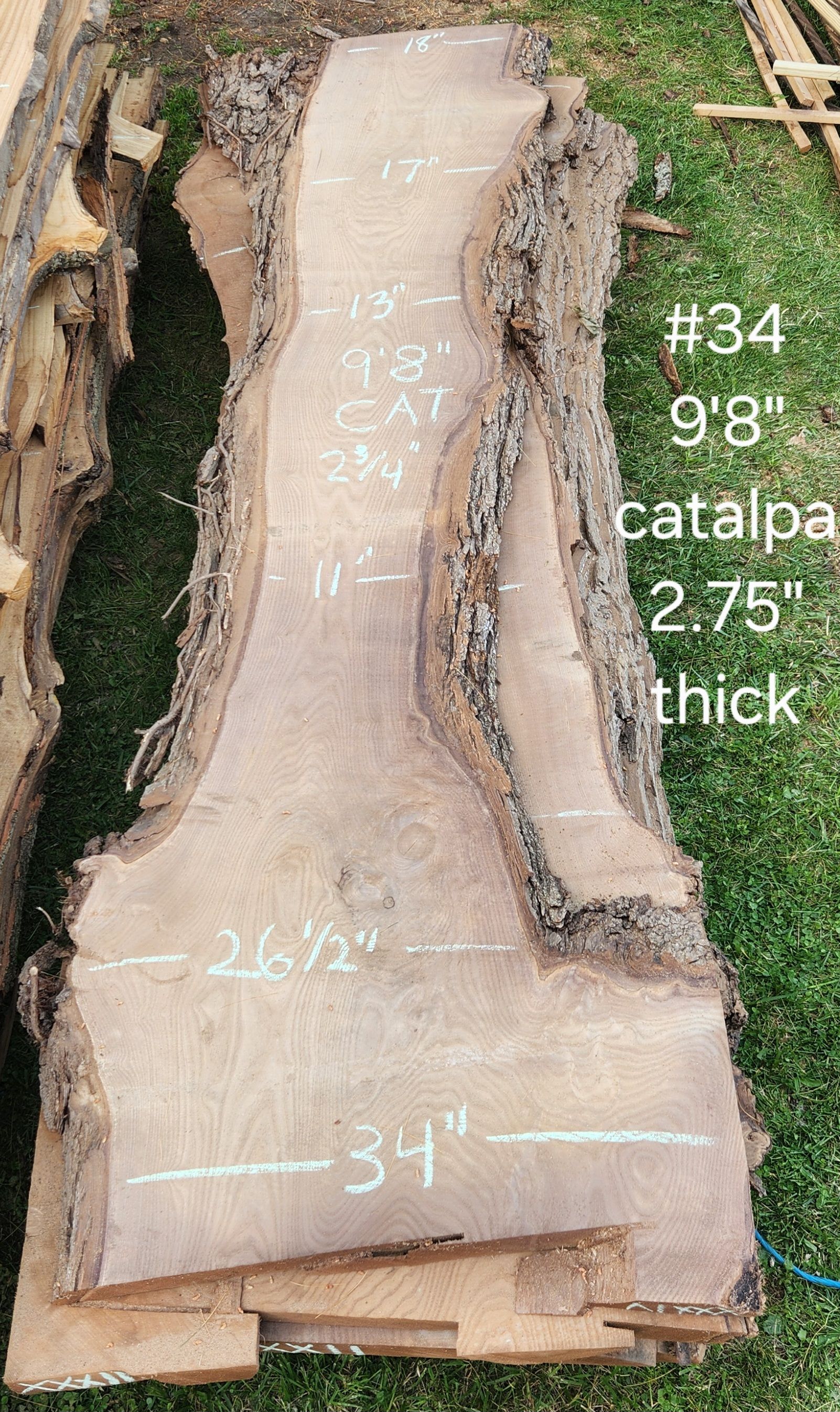 A piece of wood is sitting on top of a pallet in the grass.