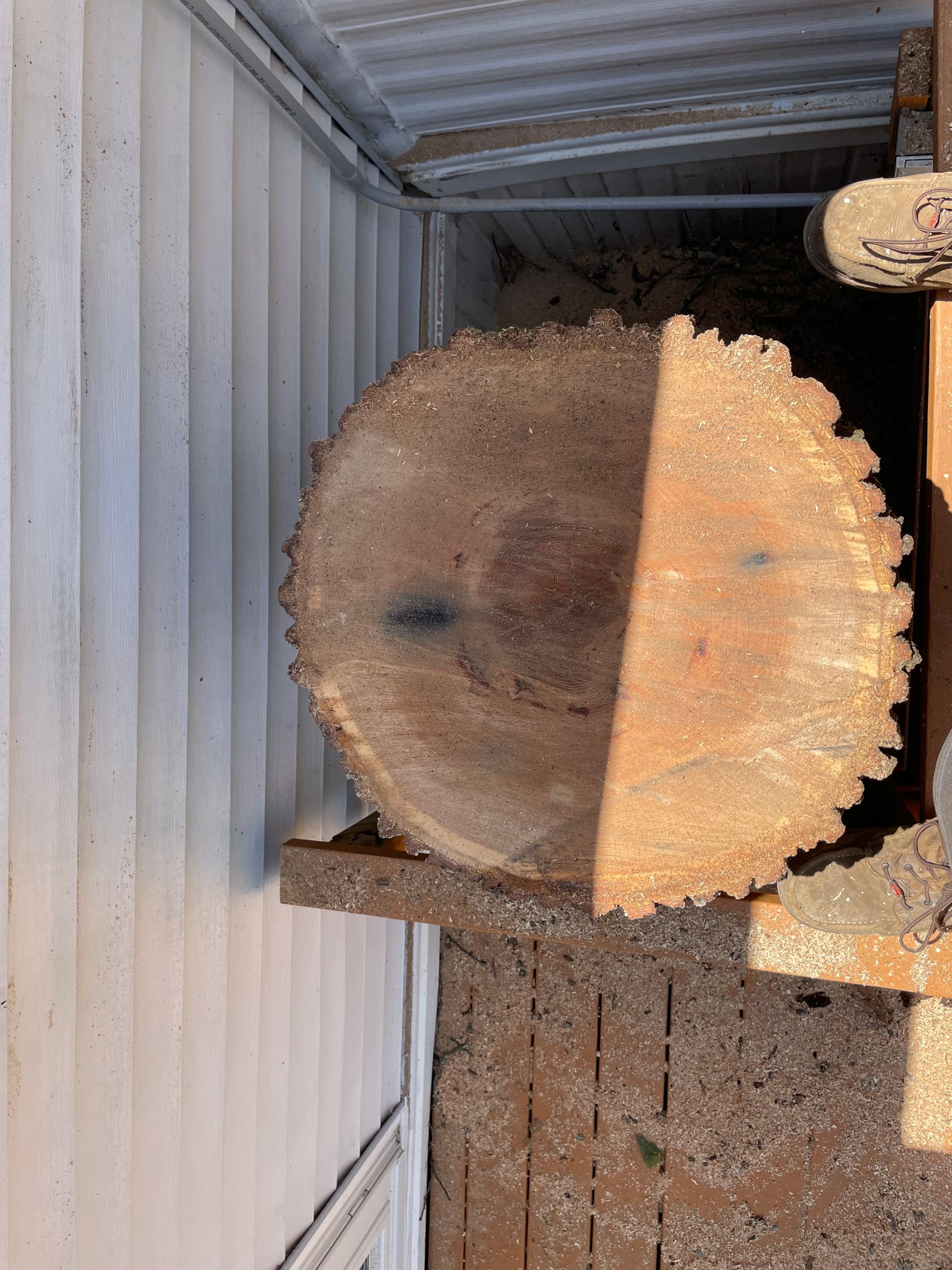 A large piece of wood is sitting on top of a wooden table.