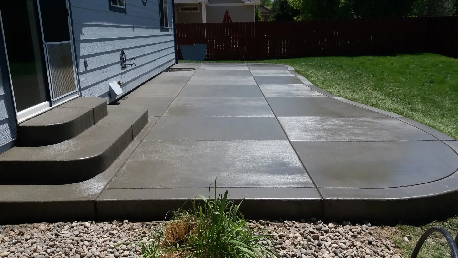 A concrete walkway leading to a house with steps
