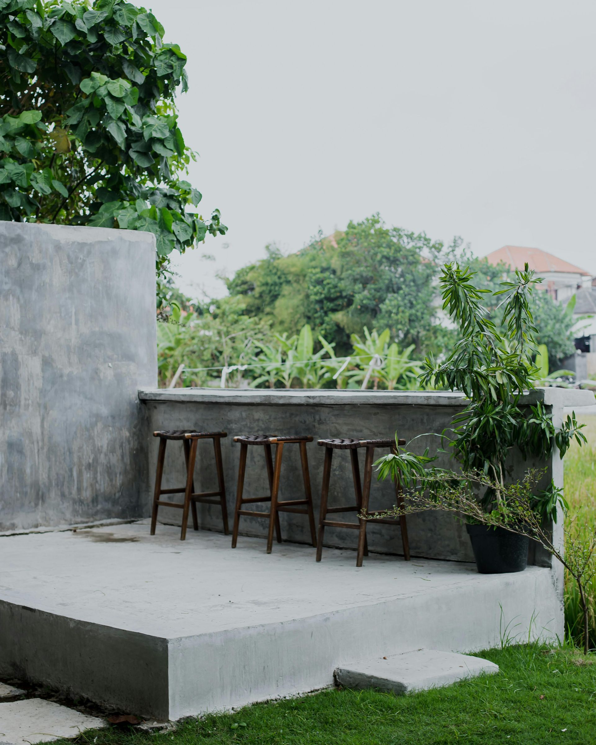 A row of wooden stools are sitting on a concrete platform
