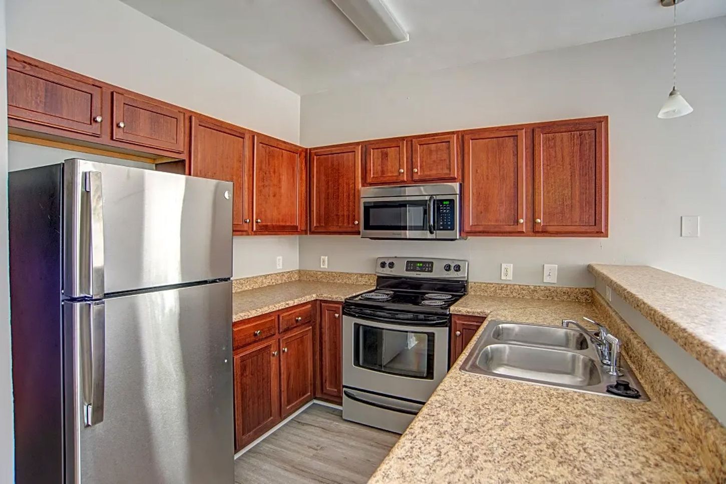 A kitchen with stainless steel appliances and wooden cabinets.