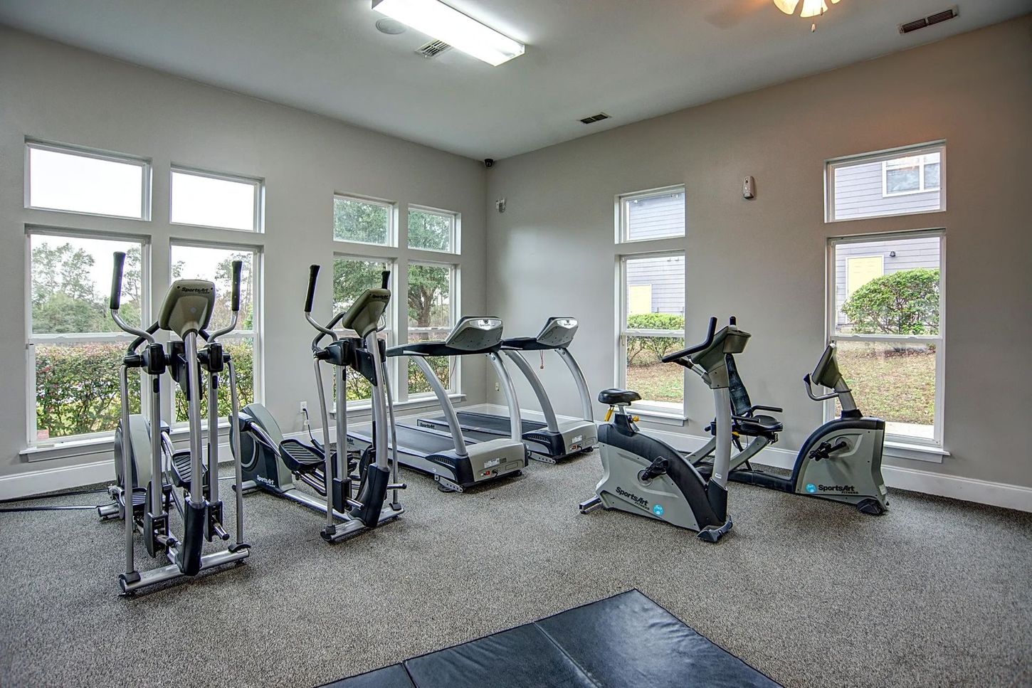 A gym with treadmills , exercise bikes , and ellipticals.