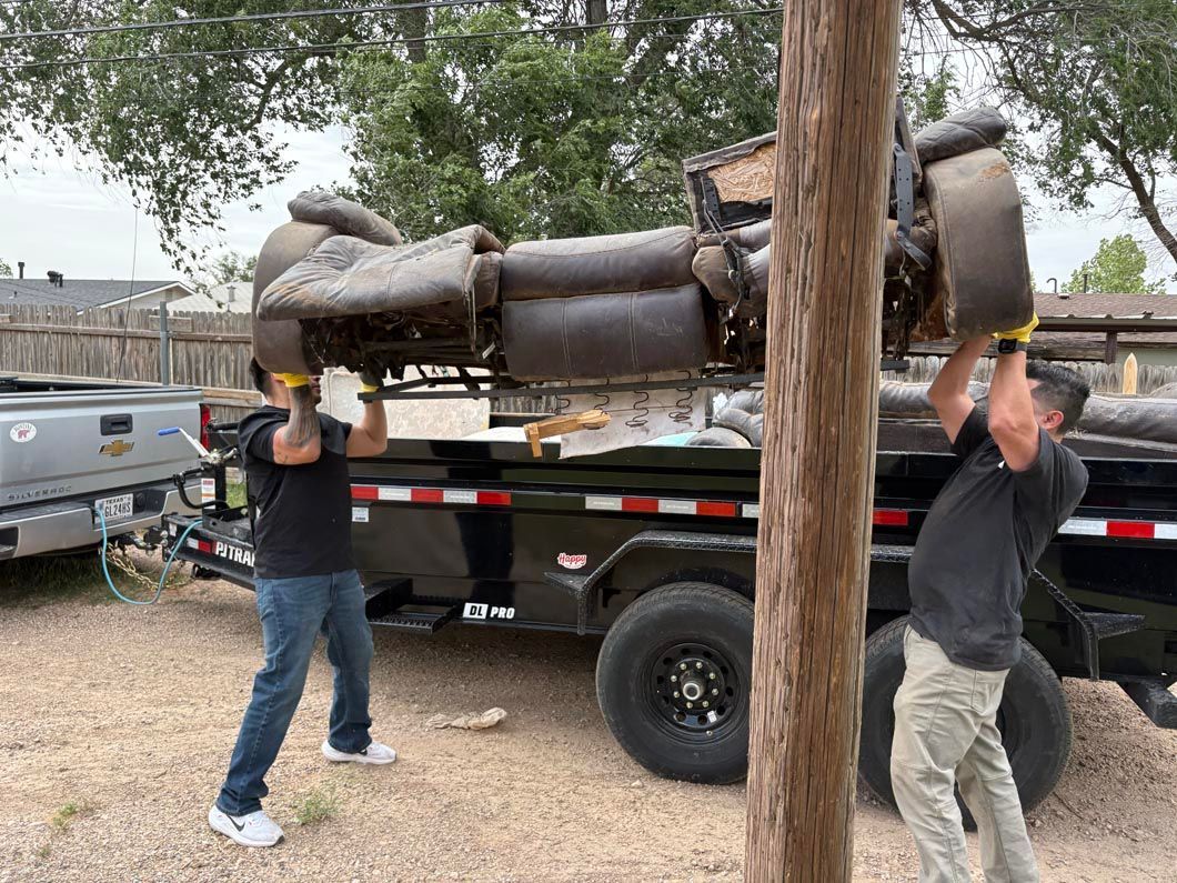 Two men are carrying a statue of a man on a trailer.
