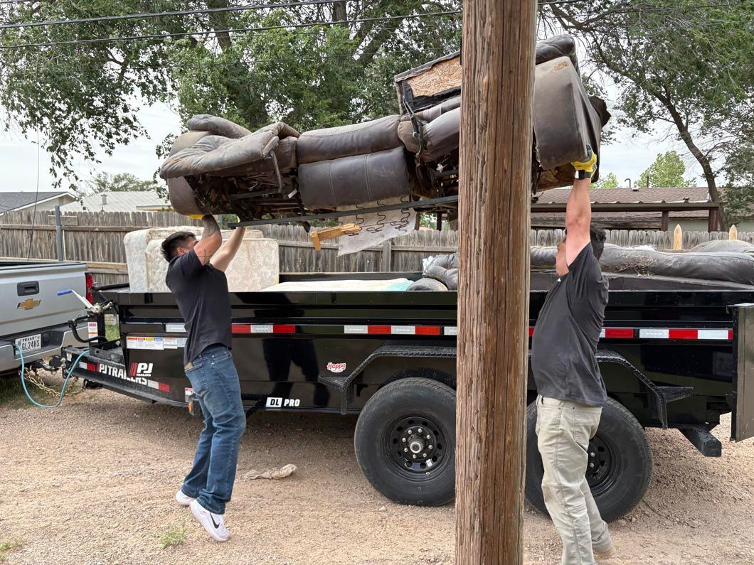 Two men are working on a trailer with a statue on top of it.