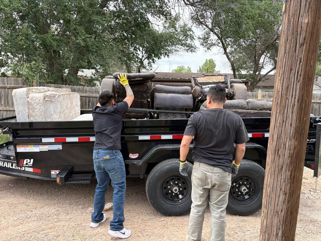 A man and a woman are standing next to a dumpster.