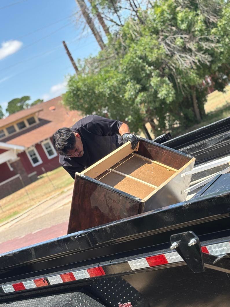 A man is loading a drawer on a trailer.