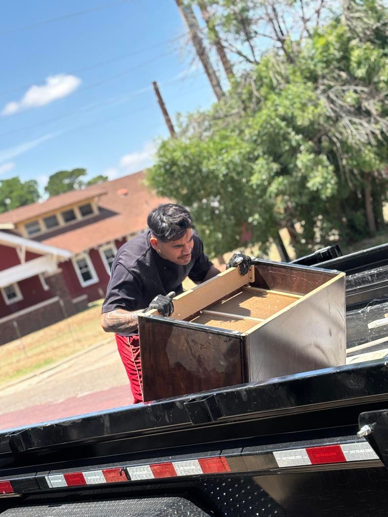 A man is loading a dresser on a trailer.