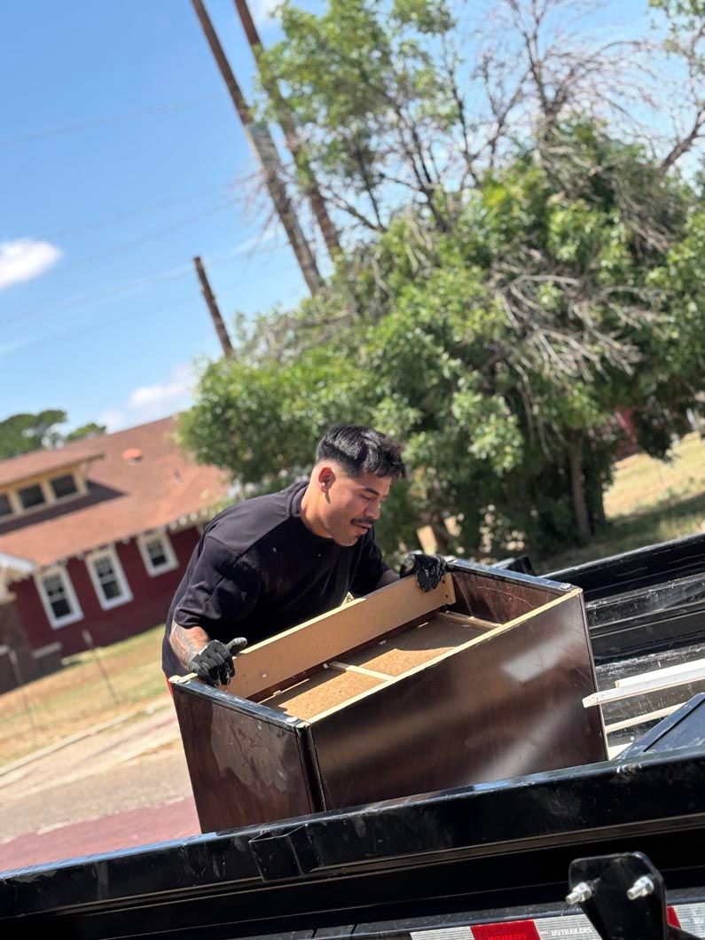 A man is carrying a wooden box on a trailer.
