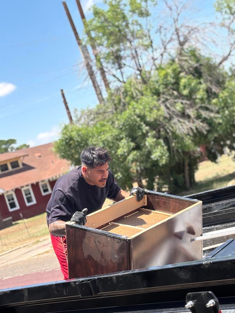 A man is loading a wooden box into a truck.