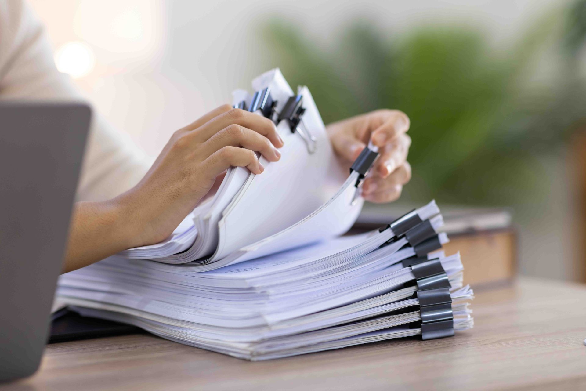 a person is holding a stack of papers and a pen .