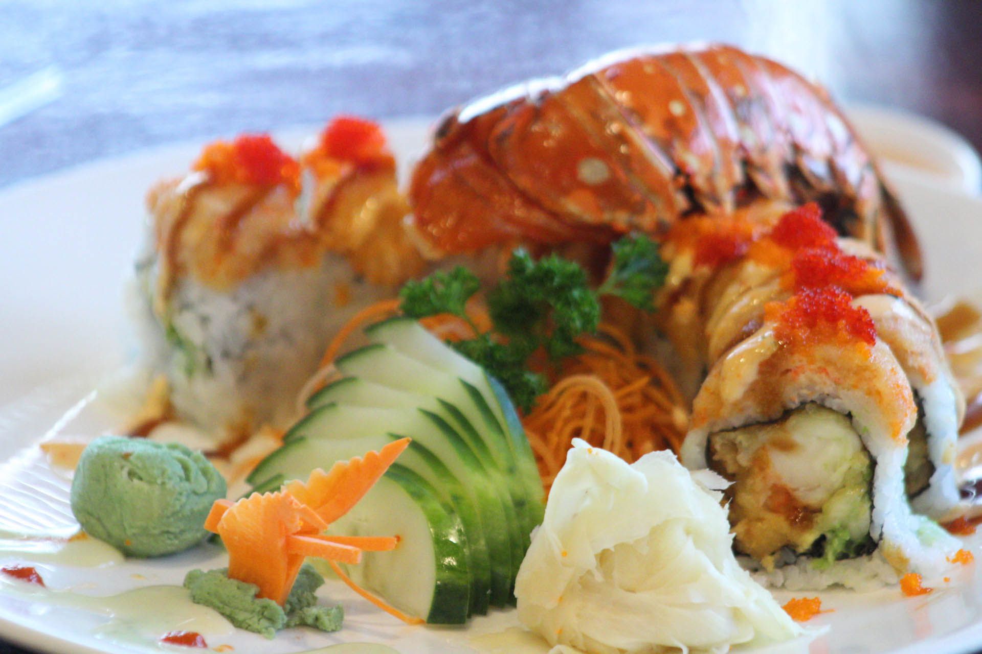 A white plate topped with a variety of sushi and vegetables.