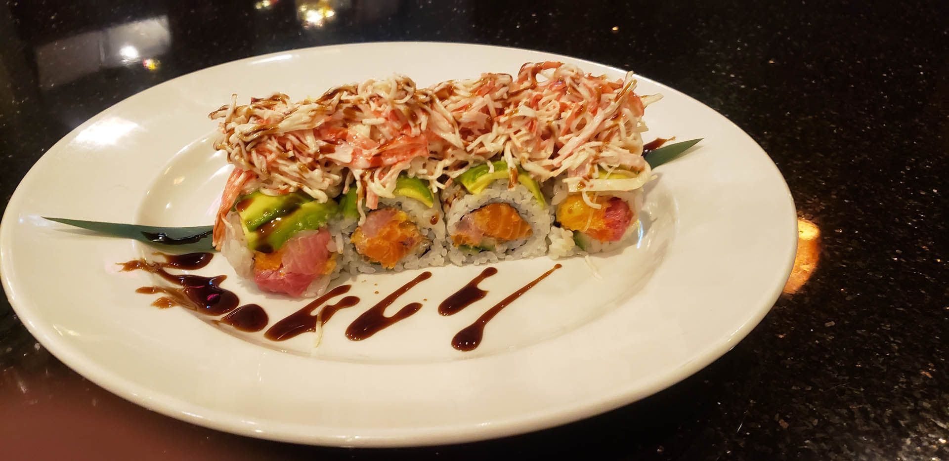A white plate topped with sushi and sauce on a table.