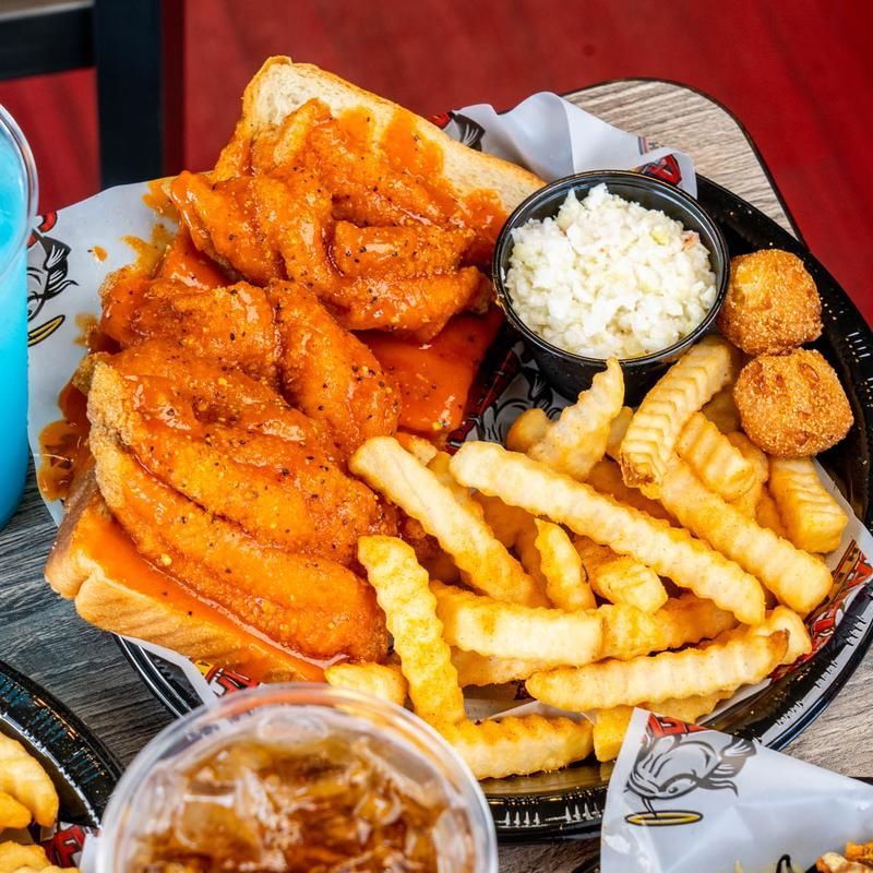 A plate of food with french fries and coleslaw on a table.