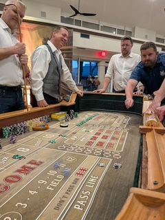 A group of men are playing a game of craps on a table.