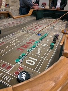 A group of people are playing a game of craps on a table.