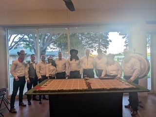 A group of people are standing around a table in a room.