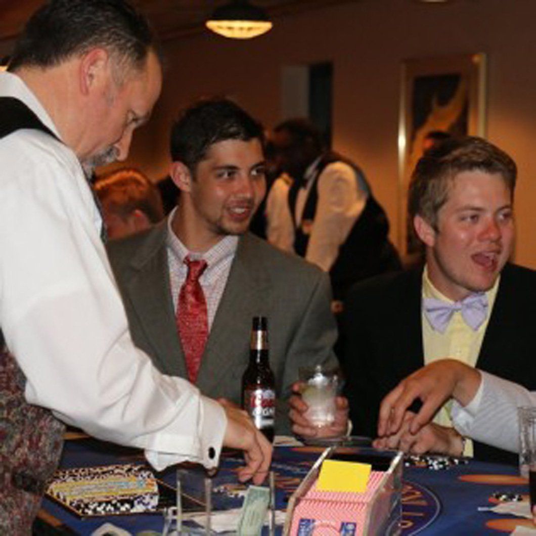 A group of men are sitting at a table playing poker