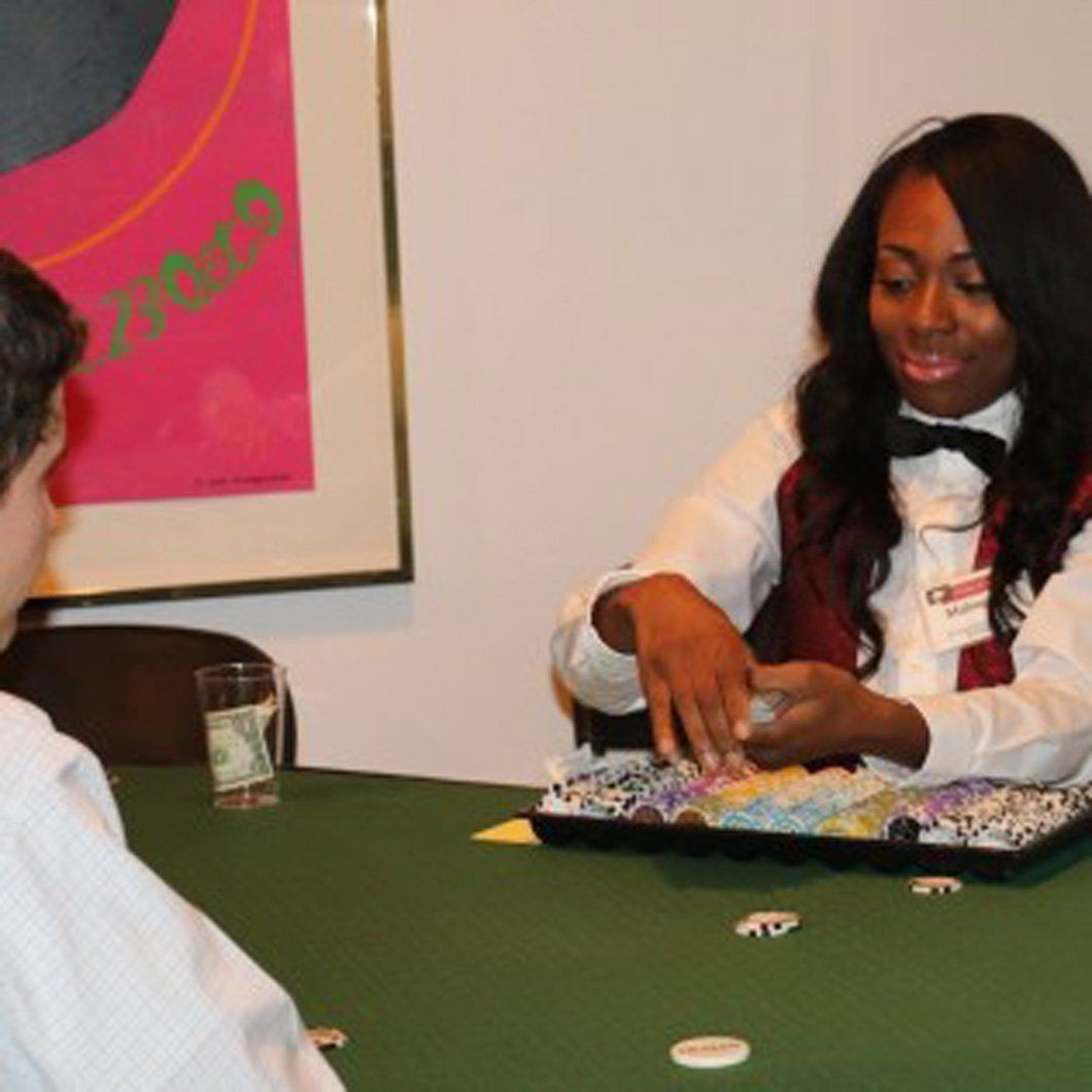 A woman in a tuxedo is playing poker with a man