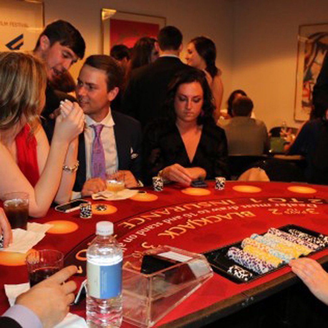 A group of people sitting around a blackjack table
