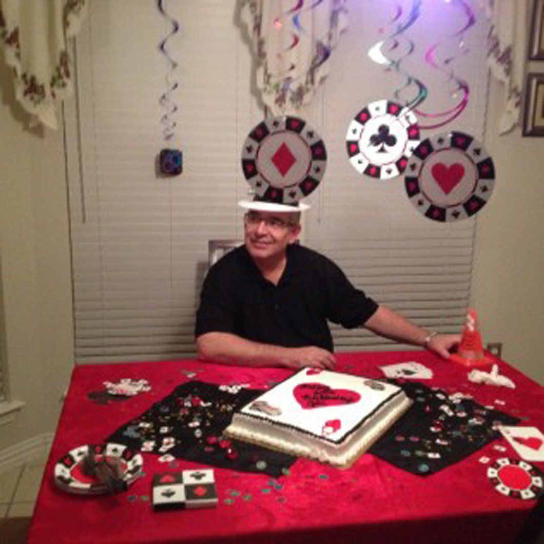 A man is sitting at a table with a cake on it