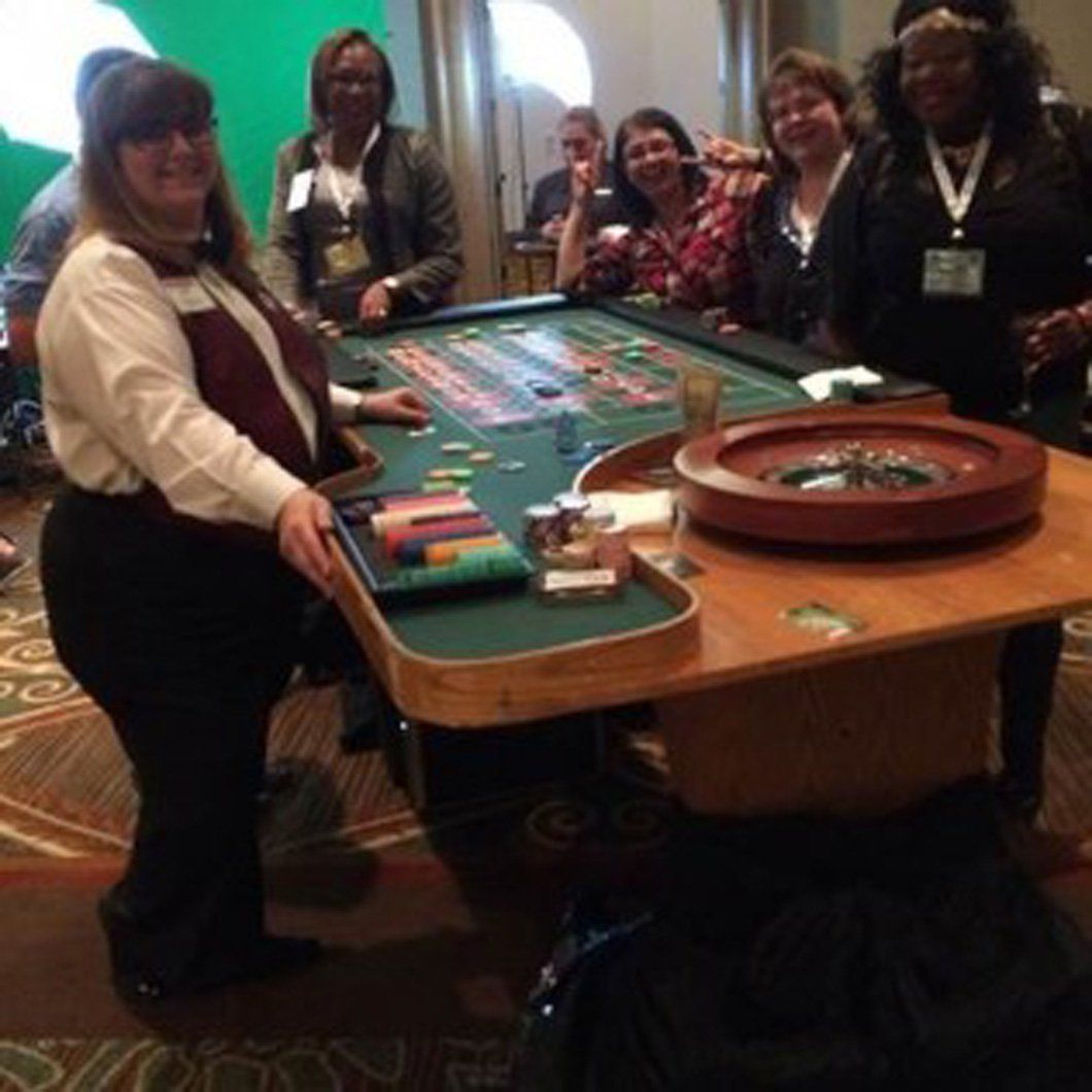 A group of people standing around a roulette table
