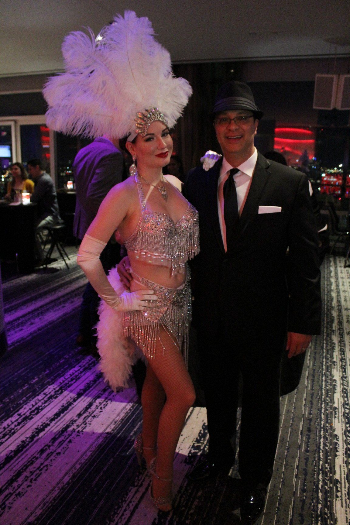 A man in a suit and tie is standing next to a woman in a costume.