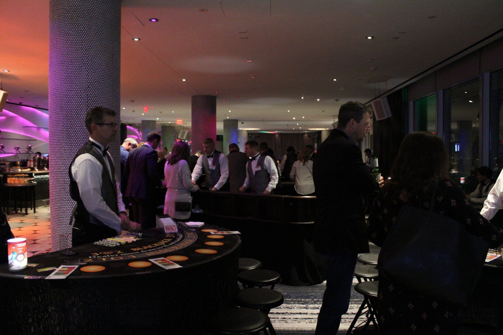 A group of people are standing around a roulette table in a casino.