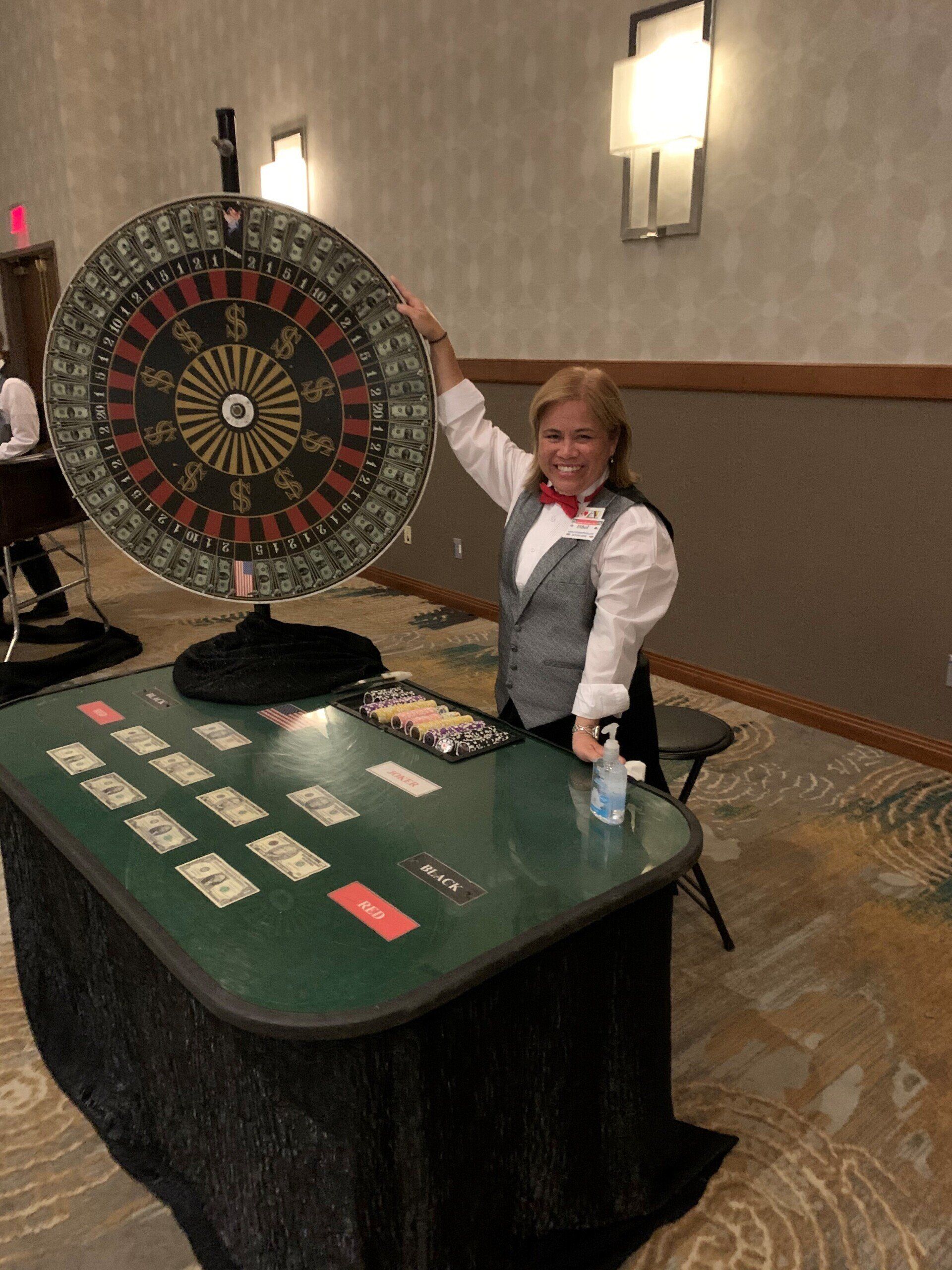 A woman is standing in front of a roulette wheel.