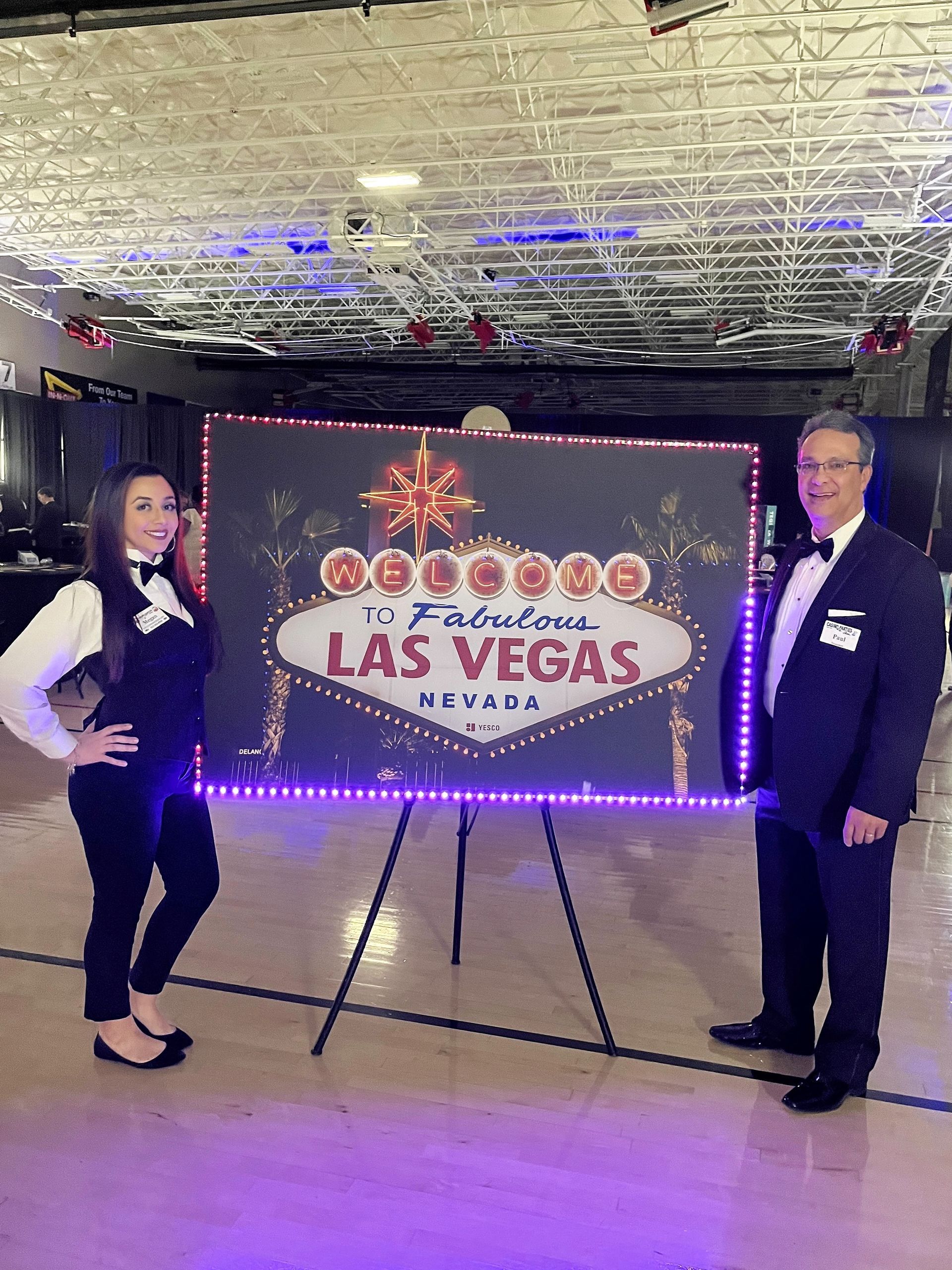 A man and a woman are standing in front of a las vegas sign