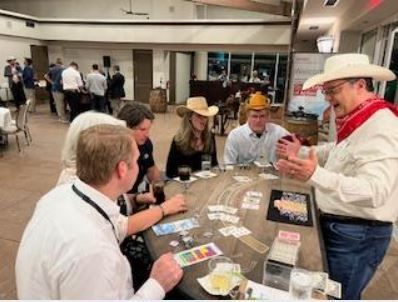 A group of people are sitting around a table playing cards.