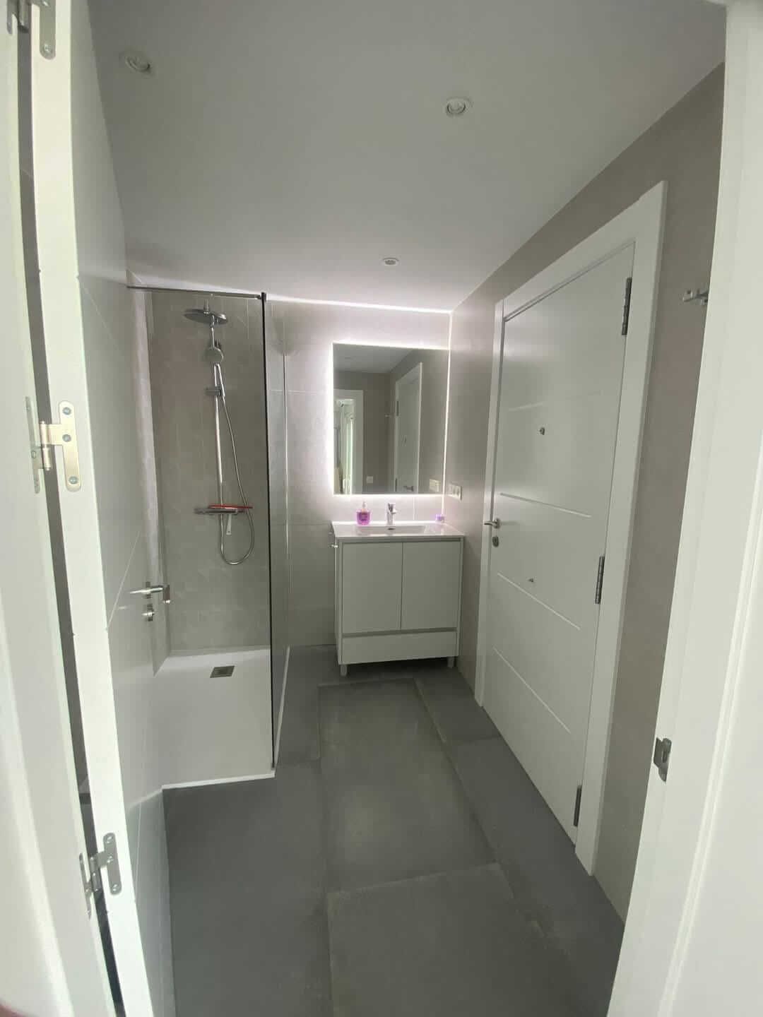 Un baño con bañera, lavabo, espejo y ducha.