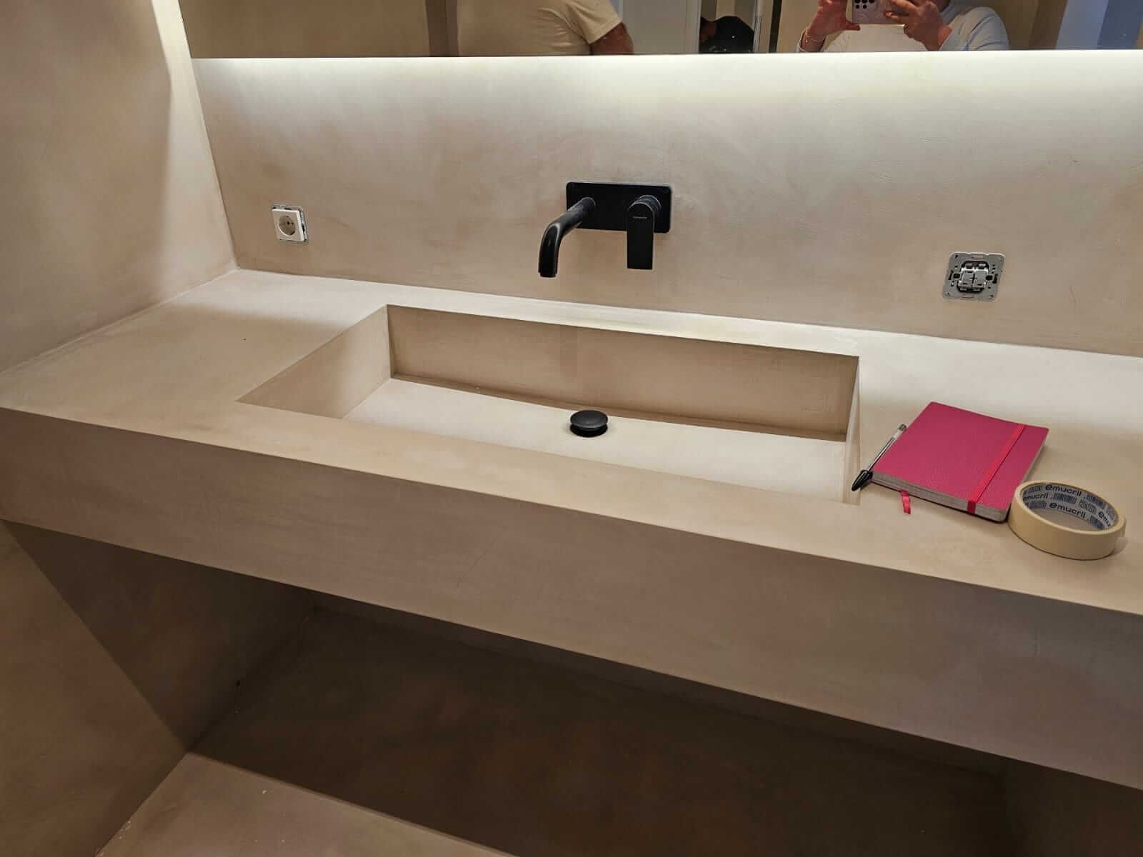 Un lavabo de baño con un libro y cinta adhesiva en el mostrador.