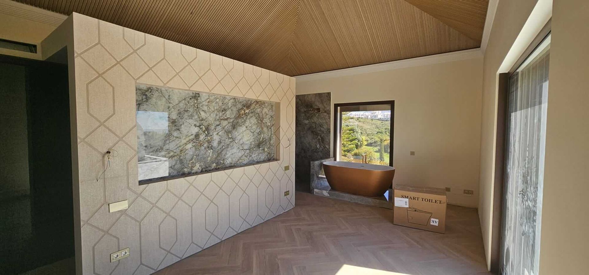 Hay una bañera en el medio de la habitación.