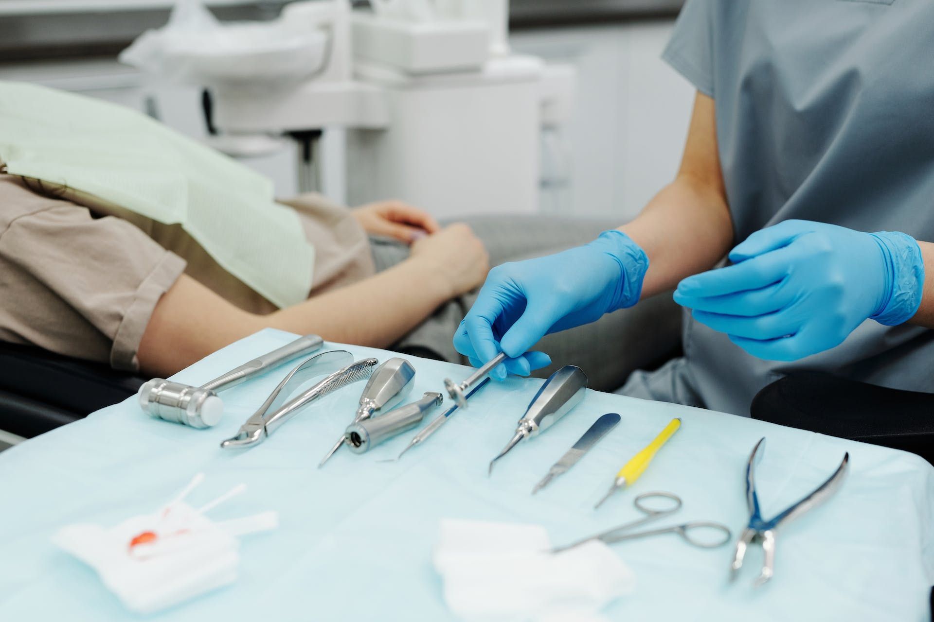 a dentist is working on a patient 's teeth while wearing blue gloves