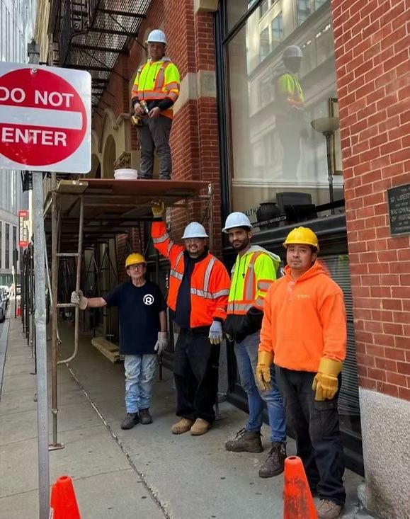 A group of construction workers standing in front of a do not enter sign