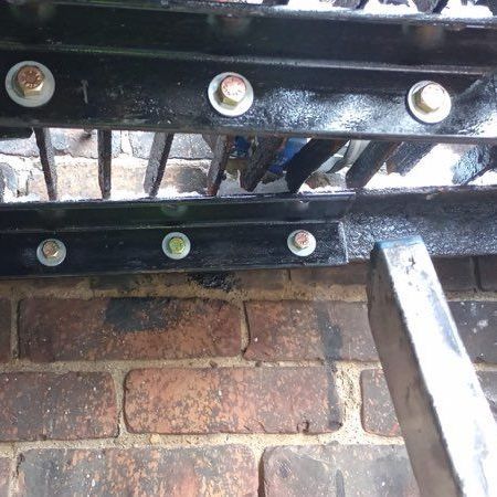 A close up of a metal object sitting on top of a brick wall.