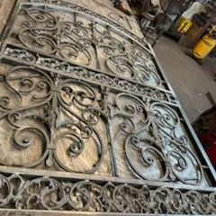 A close up of a wrought iron gate in a workshop.