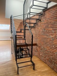 A spiral staircase in a room with a brick wall.