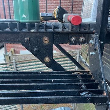 A close up of a fire escape with a drill on top of it.