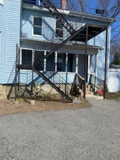 A blue house with stairs leading up to the second floor.