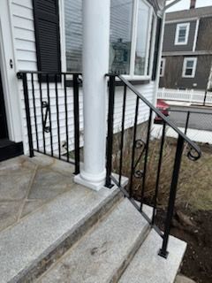 A black wrought iron railing on the steps of a house.