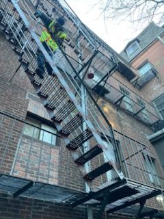 A man is standing on a set of stairs on the side of a building.