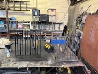 A metal fence is being built in a workshop.