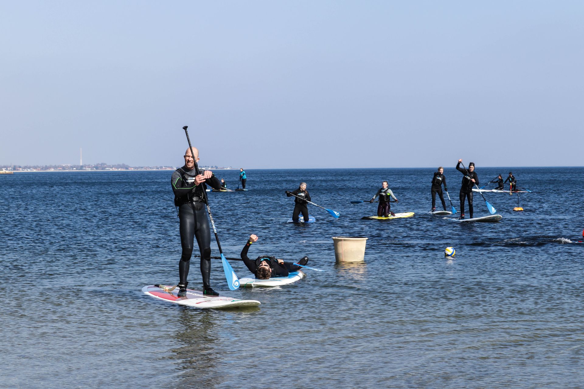 En gruppe mennesker kører på paddleboards i havet.